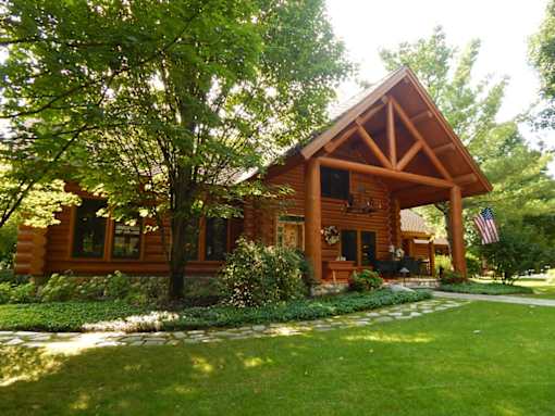 a large log cabin with a large lawn in front of it