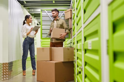 a man and a woman standing next to boxes in a warehouse