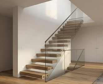 A wooden staircase with a glass railing.