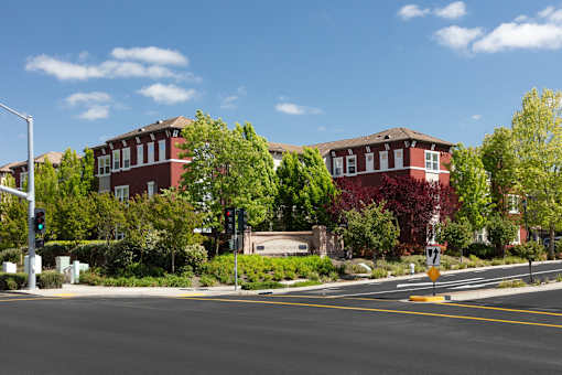A street view with a traffic light and a building in the background.
