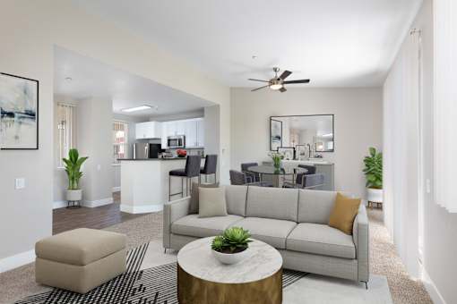 A living room with a grey couch, a coffee table, and a ceiling fan.