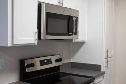 A microwave is built into a cabinet in a kitchen.