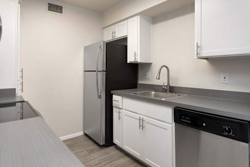 A small kitchen with a black refrigerator and white cabinets.