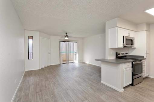 A kitchen with white cabinets and a black countertop.