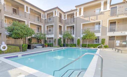 A swimming pool in front of apartment buildings.