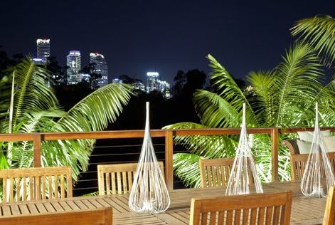 a deck with chairs and palm trees at night