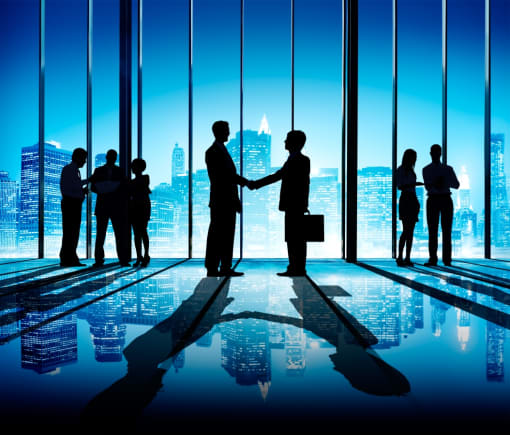 silhouettes of business people shaking hands in a conference room