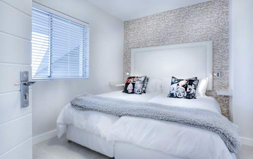 a white bedroom with a bed and a window