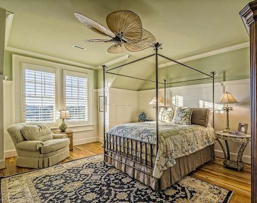 a bedroom with a bed and a ceiling fan