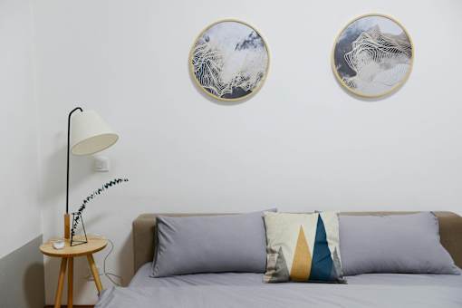 a bedroom with a bed and two paintings on the wall