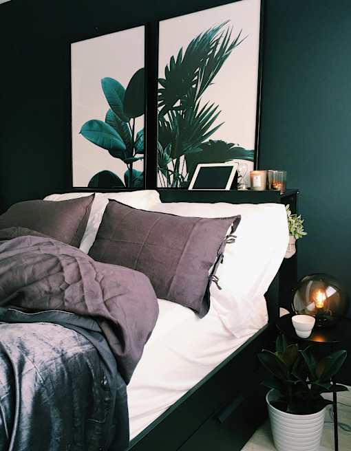a bedroom with a bed with pillows and a painting on the wall