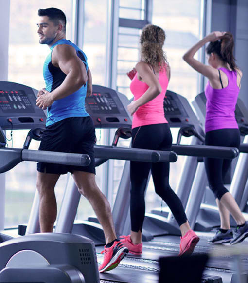 a group of people walking on a treadmill at a gym