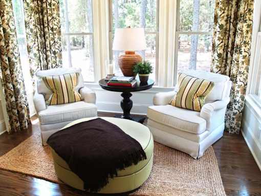 A living room with white furniture and a large window.