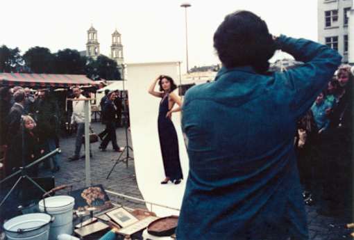 a man taking a picture of a woman in front of a mirror