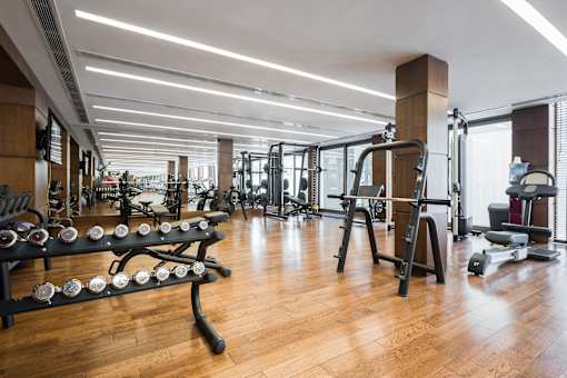 a gym with weights and other exercise equipment on a wooden floor