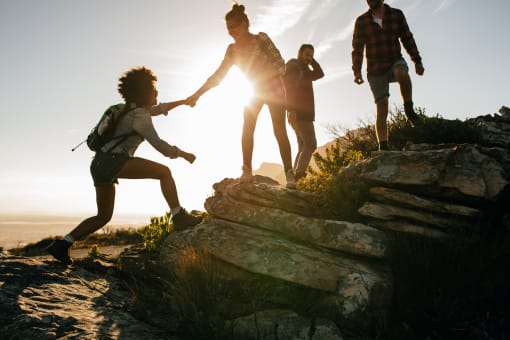 a group of people hiking up a mountain holding hands