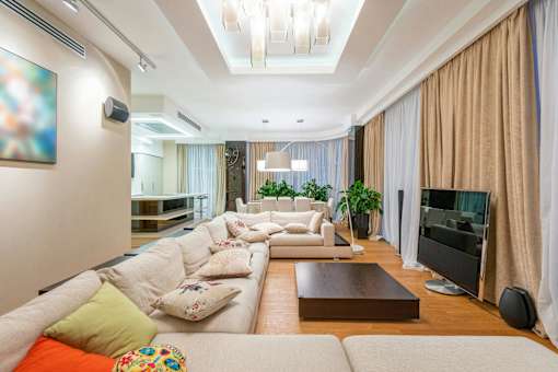 A modern living room with a white sofa and a television.