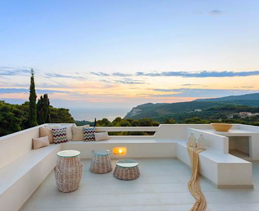 A patio with a table and chairs overlooking a scenic view.