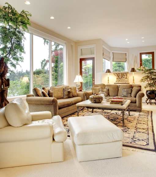 A living room with a large window and a view of trees.