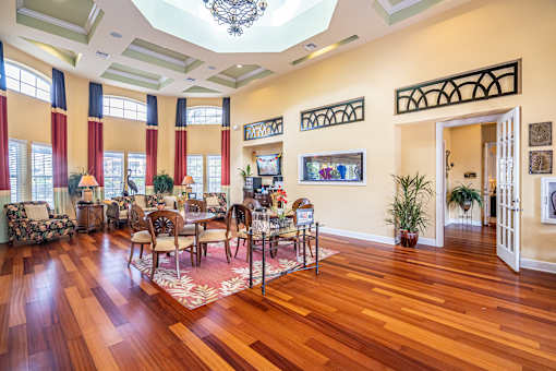 A large room with a wooden floor and a chandelier hanging from the ceiling.