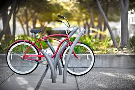 A red bicycle is parked on a grey bike rack.