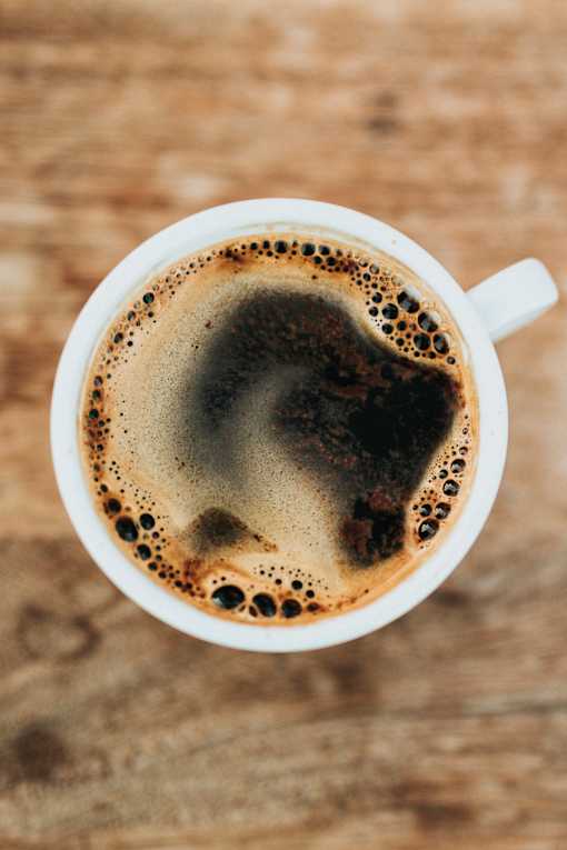 A cup of coffee with a heart-shaped foam on top.