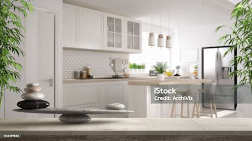A modern kitchen with white cabinets and a marble countertop.