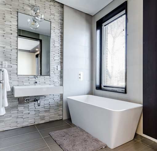 a bathroom with a white bathtub and a sink with a mirror above it