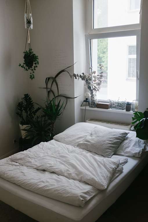 a bedroom with a bed in front of a window