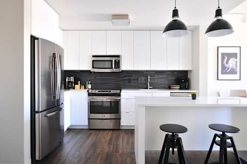 a kitchen with white cabinets and stainless steel appliances