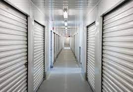 a long hallway with closed doors in a prison