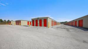 a row of garages with red doors in a parking lot