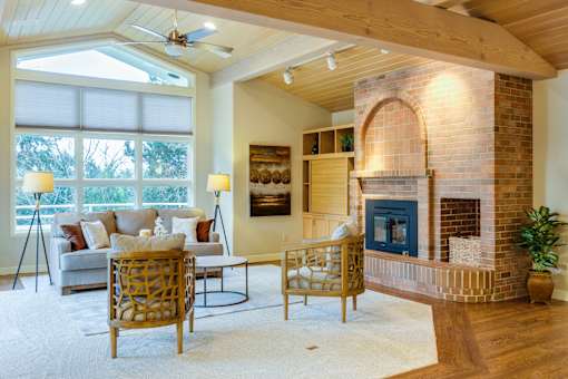 A living room with a fireplace and a ceiling fan.