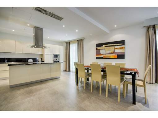 A modern kitchen with a dining table set for six.