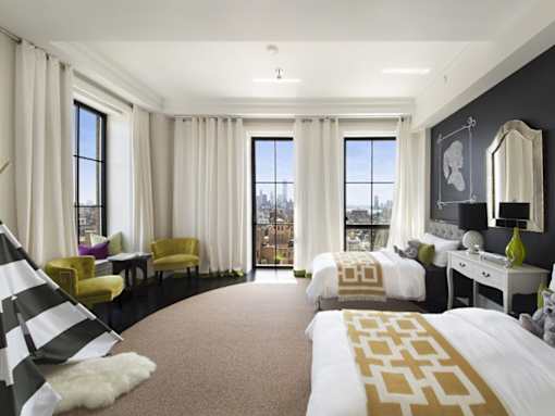 A bedroom with a large bed and a yellow chair.