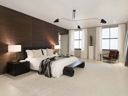 A modern bedroom with a large bed and a chair.