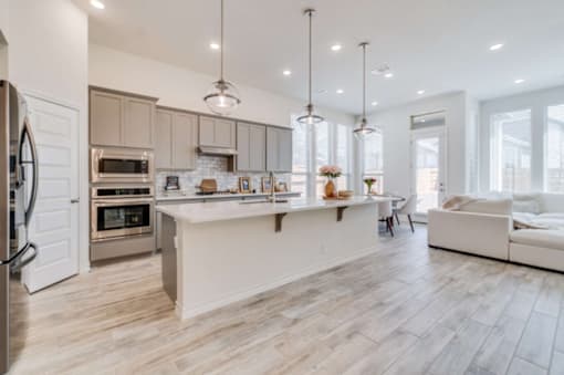 A modern kitchen with a white island and a refrigerator on the left at Bluebell Ridge, Colorado 80202