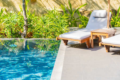 A pool with a chair and table by it.