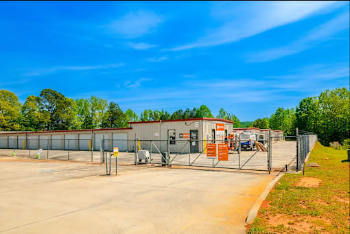 a fenced in area with a building in the background