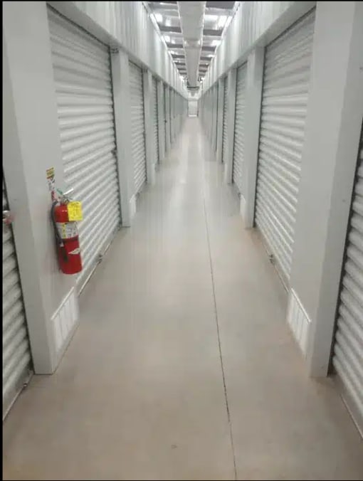 an empty hallway with doors and a fire hydrant on the wall