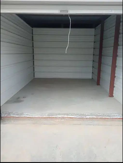 the inside of a garage with a white floor and a door