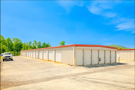 a large warehouse building with a car parked in front of it