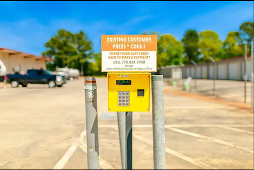 a parking meter in a parking lot with a yellow sign
