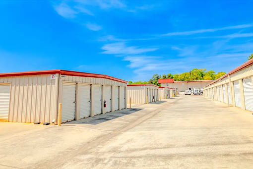 a row of sheds in a parking lot with a blue sky