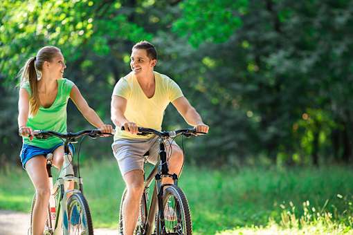 a man and a woman riding bikes in the park