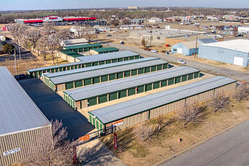 A large industrial area with multiple buildings and a train in the background.