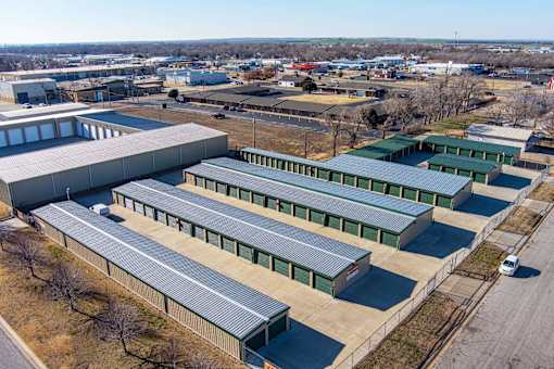 A large industrial building with a grey roof and green trim.
