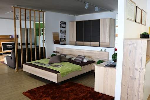 A bedroom with a bed, a couch, and a cabinet.