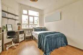 A bedroom with a bed, desk, and chair.