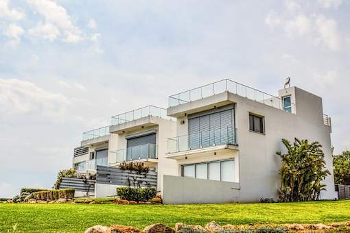 A modern house with a balcony and a flag on top.